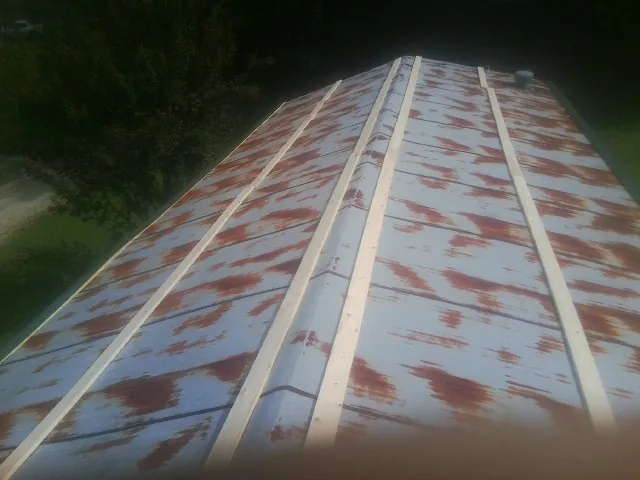 Rusted metal roof panels with new wood purlins before replacement — Storm Damage Roof Repair in Newark by Roofing Brothers